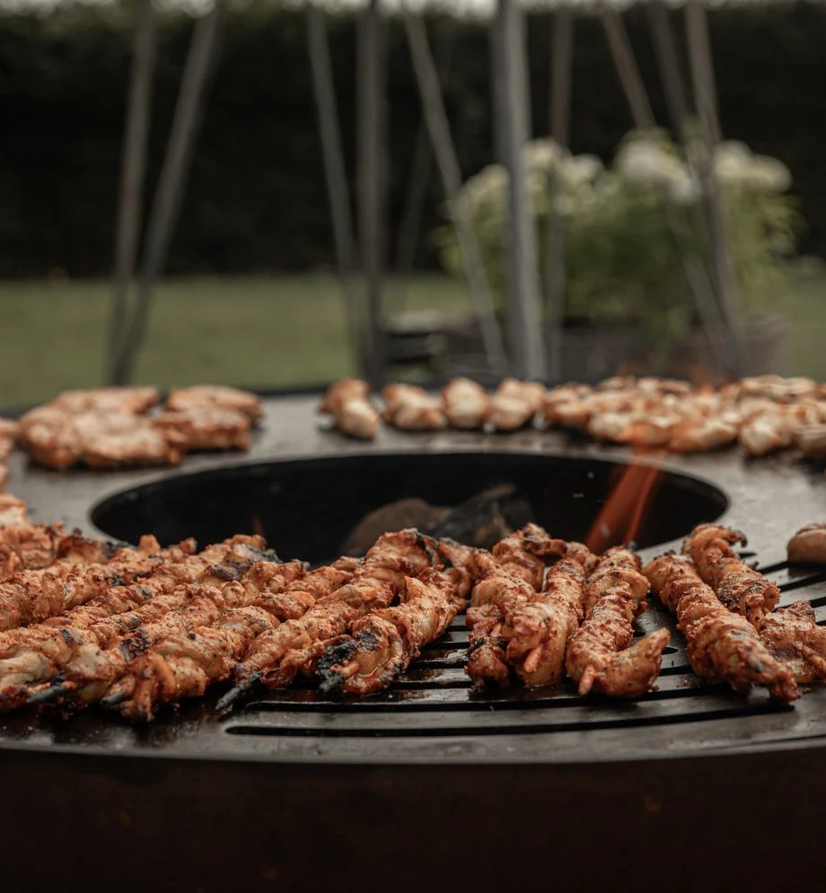 Spiesen op een ronde vuurschaal-barbecue