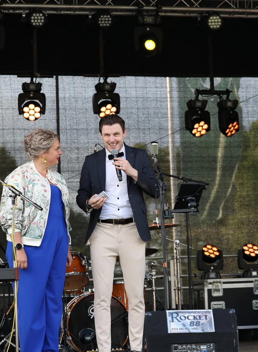 Presentatoren met microfoon op een podium