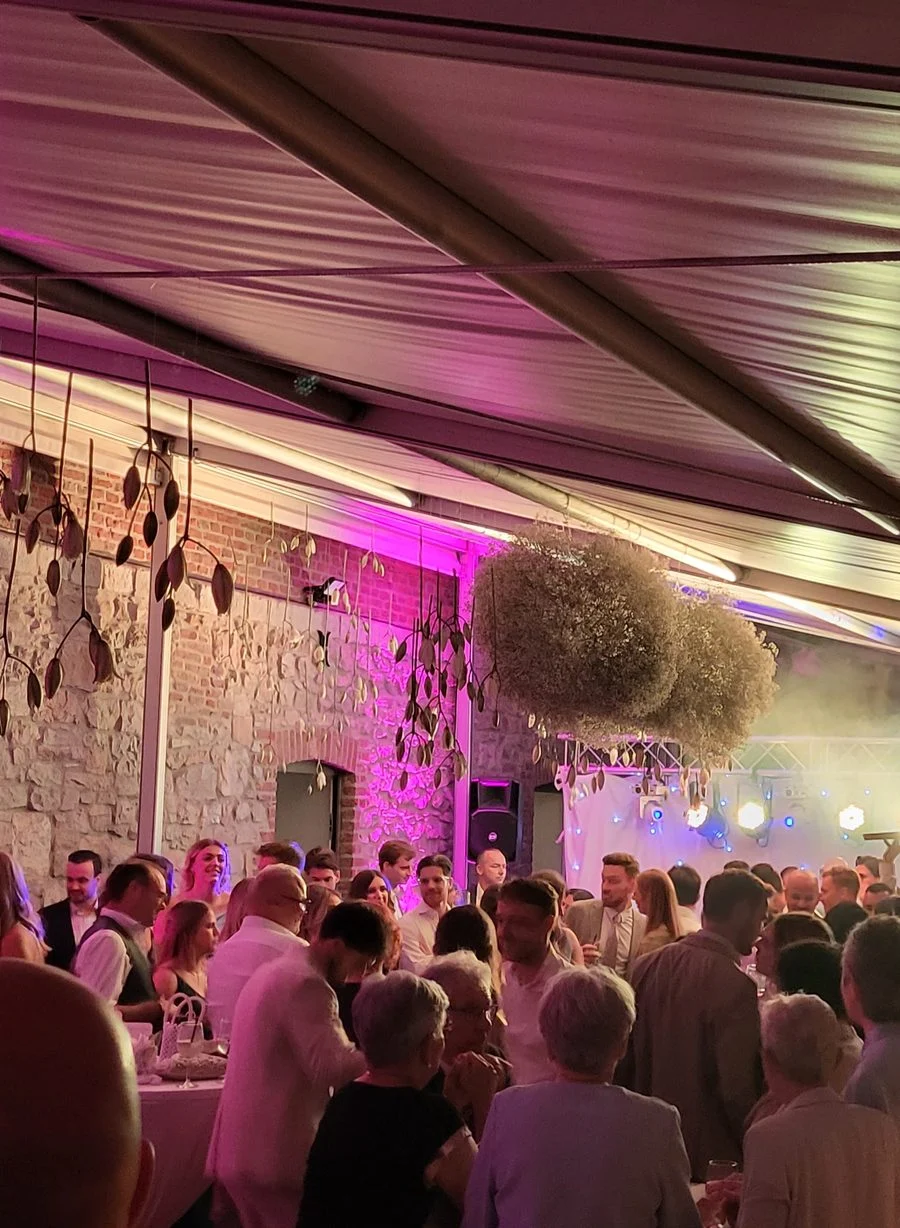 Feestende gasten in een versierde tent met gekleurd licht