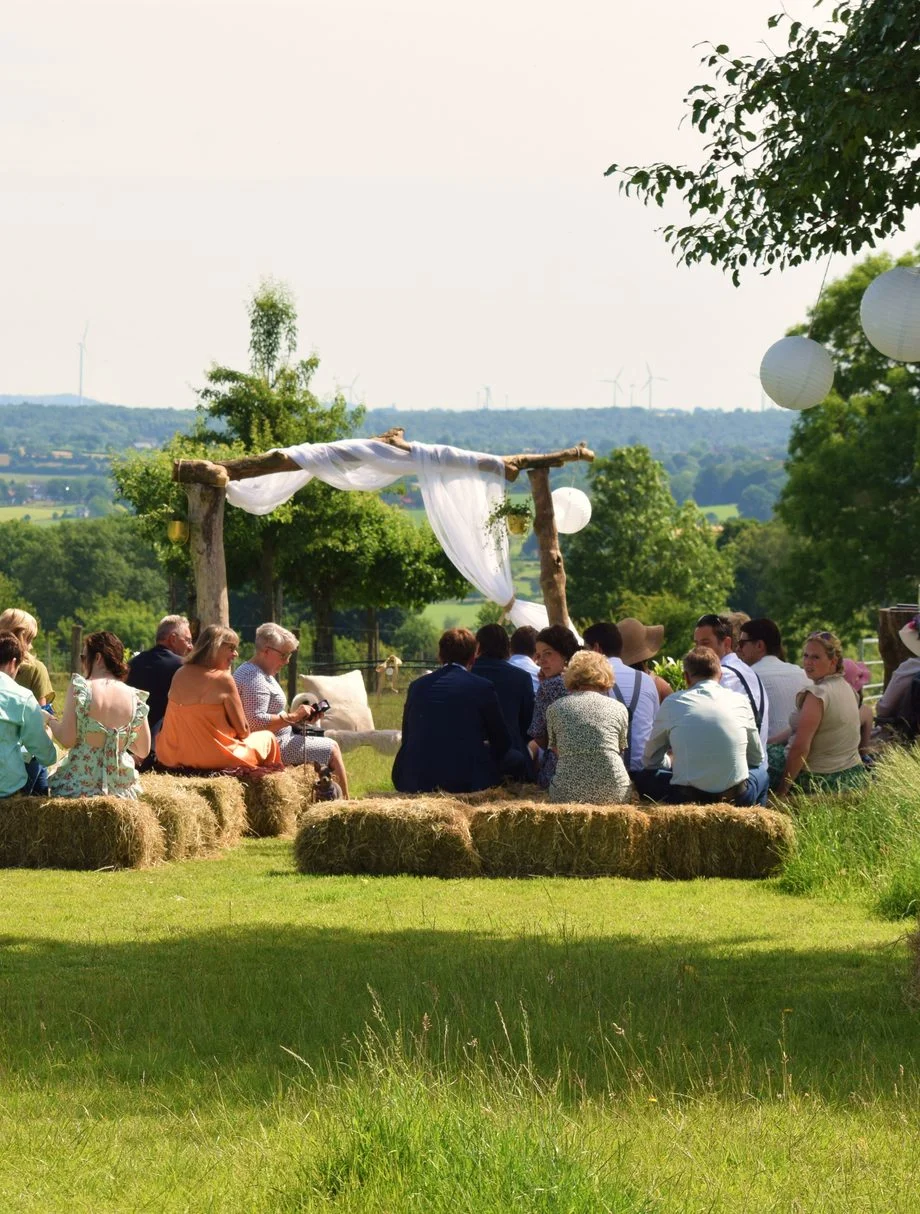 Ceremonie buiten met gasten op strobalen