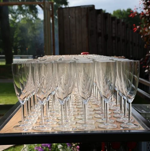 Rijen champagneglazen op een tafel buiten