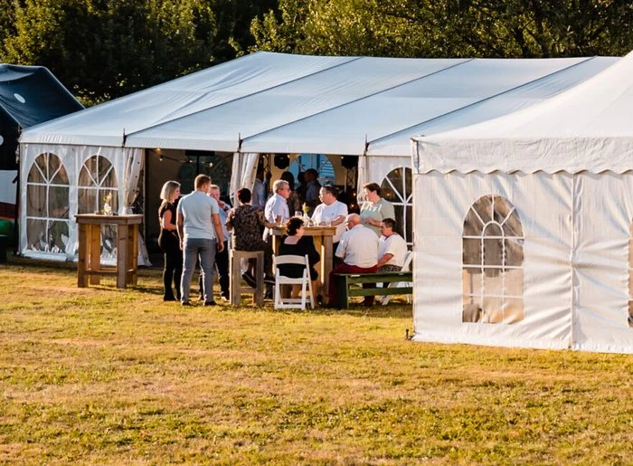 Witte partytent met gasten in het gras