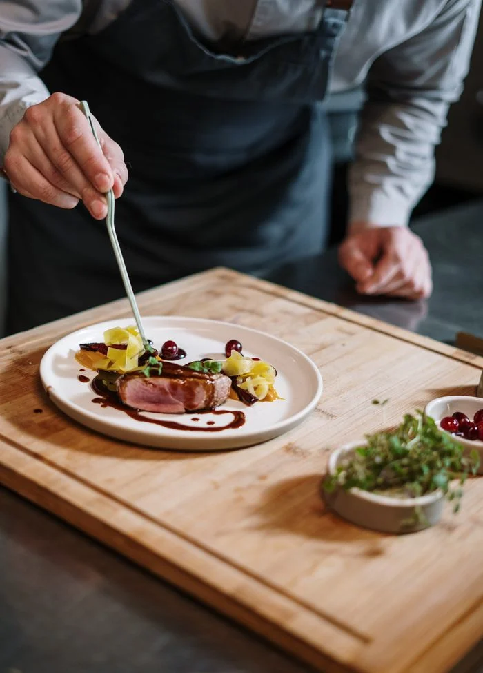 Chef maakt een bord met vlees op