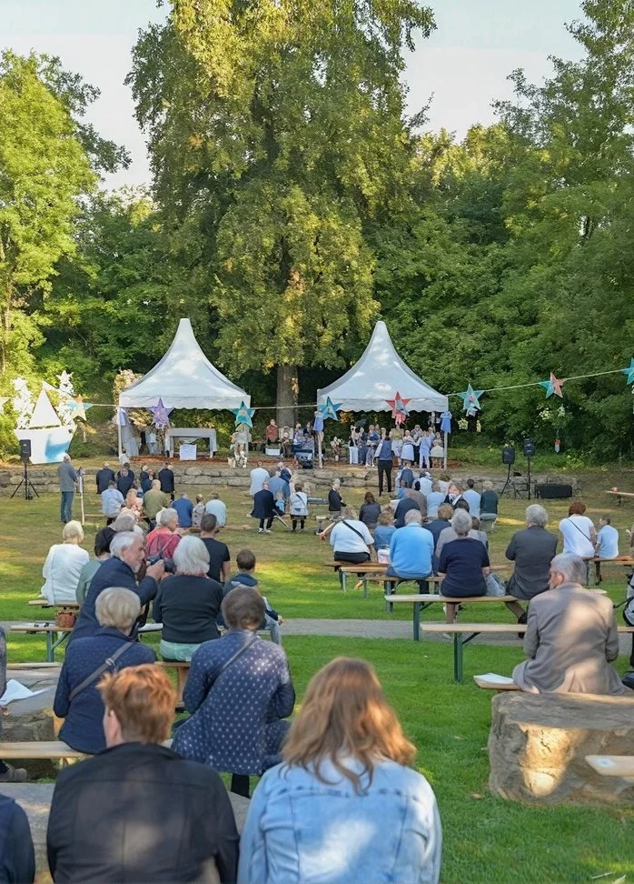 Publiek op het gras bij witte pagodetenten