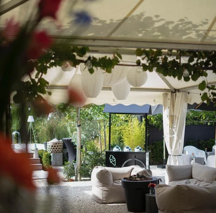 Lounge met witte banken onder een tent