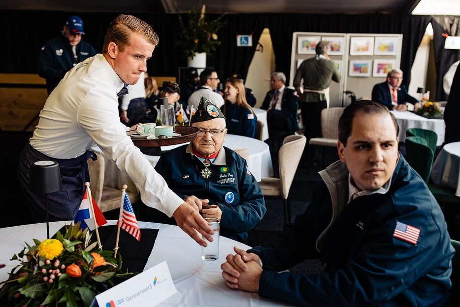Ober bij veteranen aan tafel tijdens een diner