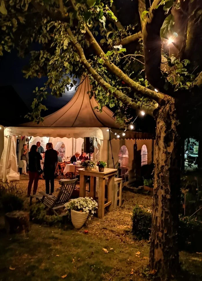 Verlichte tent tussen de bomen in de avond