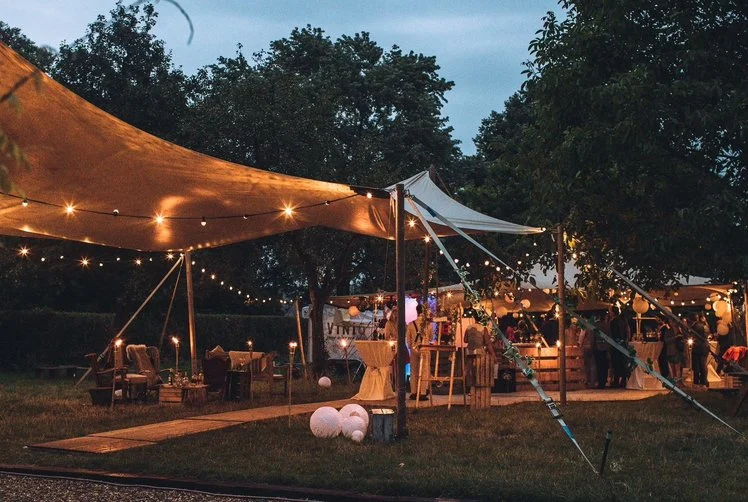Stretchtent met lichtjes tussen de bomen