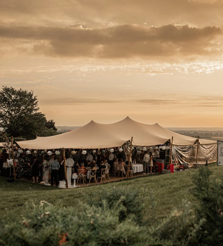 Stretchtent in een weiland bij zonsondergang