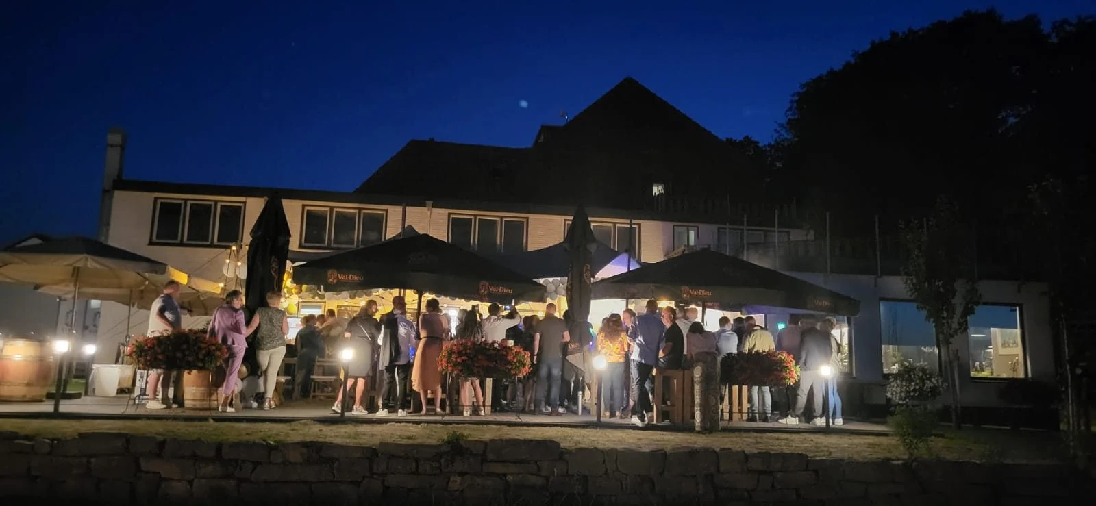 Terras met parasols en gasten in de avond