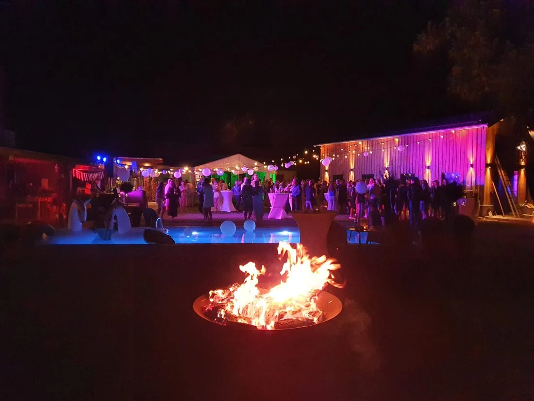 Vuurkorf bij een verlichte tent in de avond