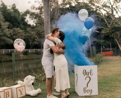 Stel met een blauw rookkanon bij een gender reveal