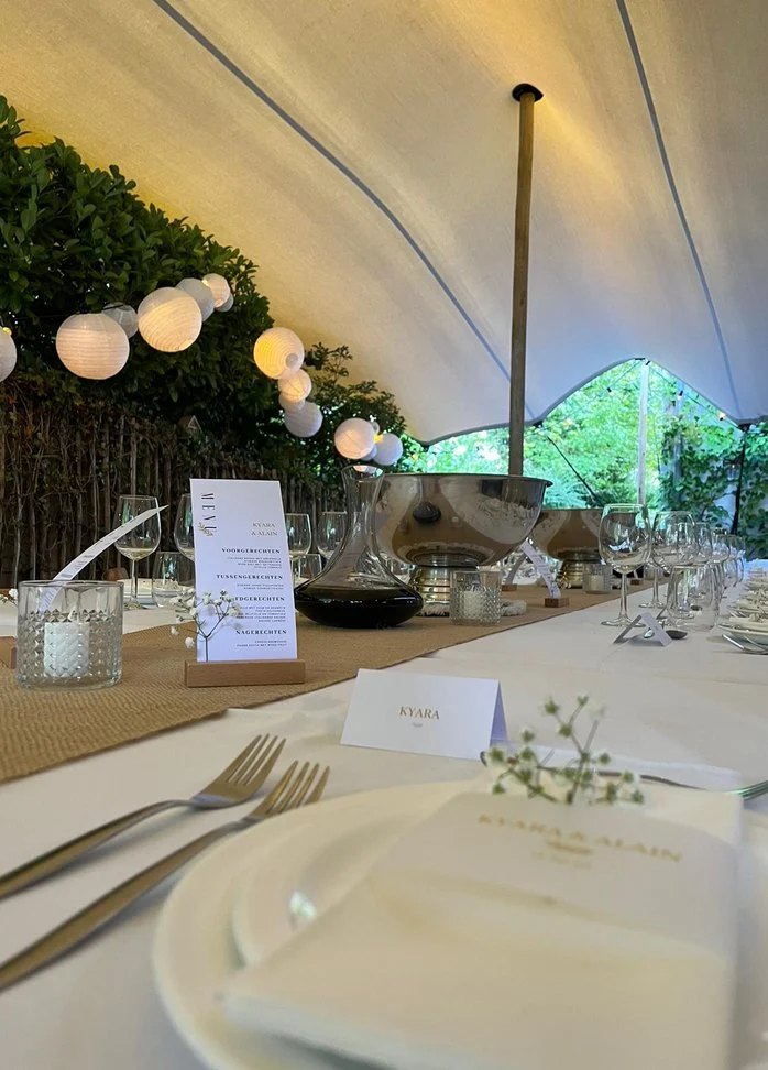 Gedekt bord met menukaart onder een tent