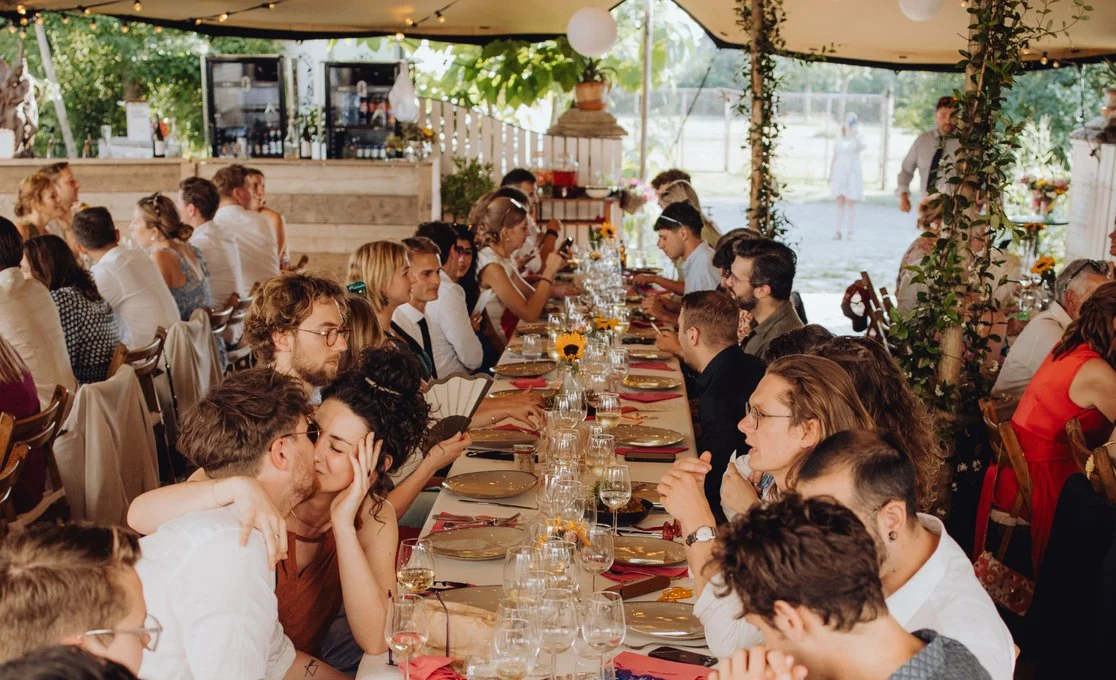 Gasten aan een lange tafel tijdens een feest