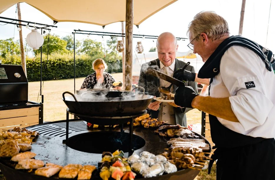 Koks bij een vuurschaal-barbecue onder een tent
