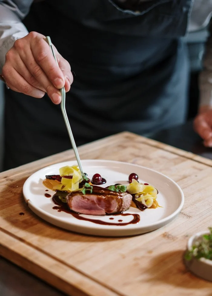 Chef maakt een bord met vlees op