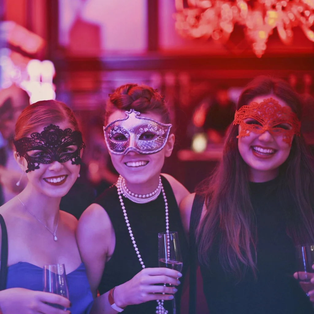 Gasten met maskers op een gemaskerd bal