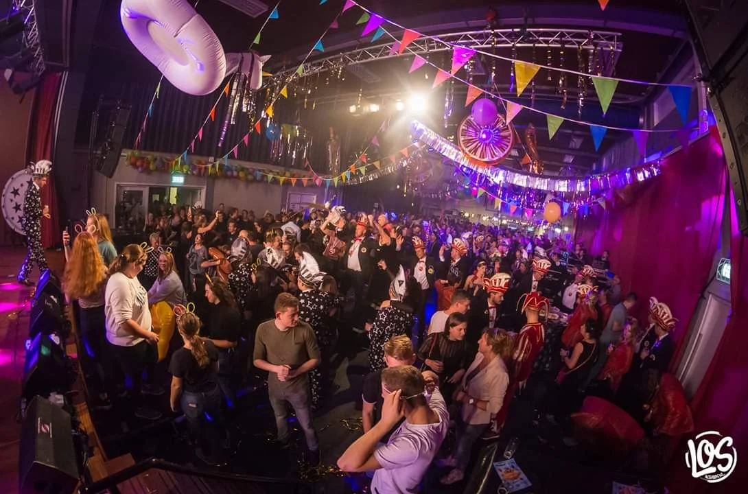 Volle zaal tijdens een feest met vlaggetjes