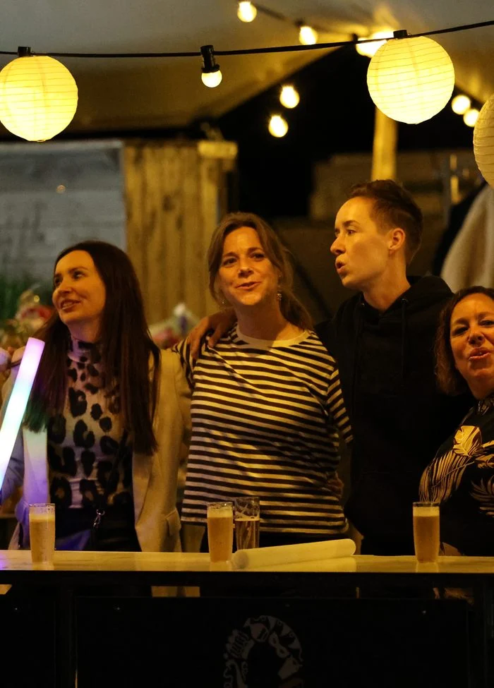 Gasten aan de bar onder lampionnen