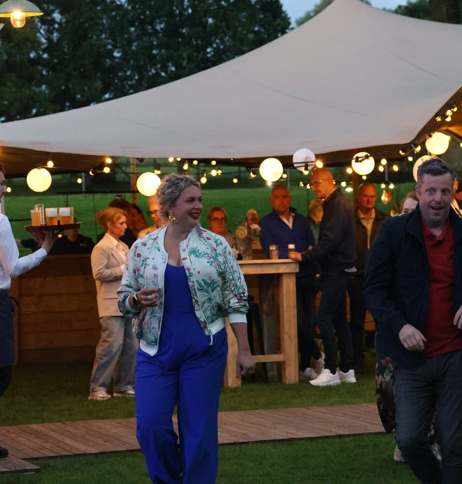 Gasten onder een stretchtent met lampionnen