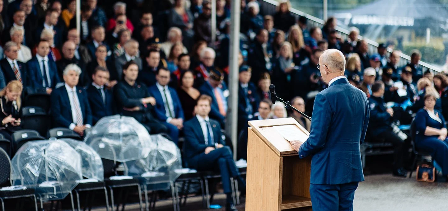 Spreker achter een katheder voor publiek