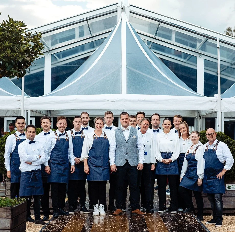Het ViniQ-team voor een tent