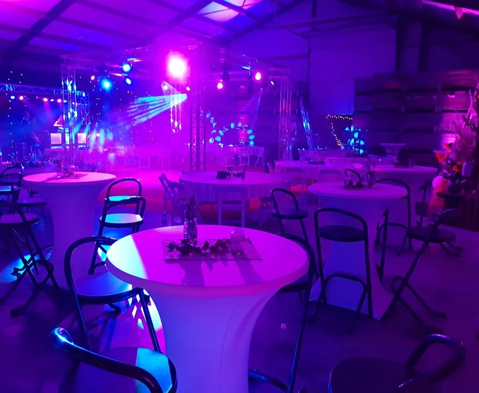 Feestzaal met statafels in paars licht