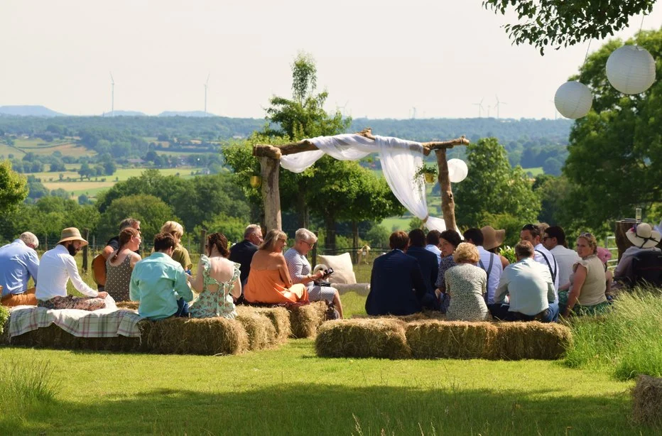 Gasten op strobalen bij een ceremonie