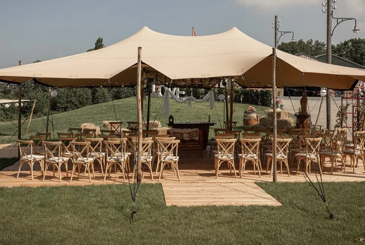 Stretchtent met houten stoelen in het gras