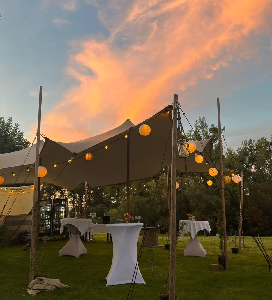 Stretchtent met lampionnen bij zonsondergang