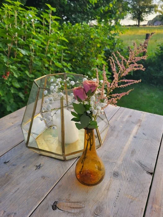 Lantaarn met bloemen op een houten tafel