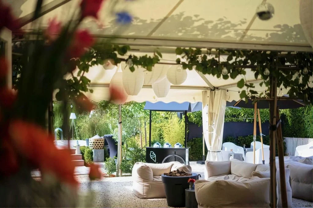 Lounge met witte banken onder een tent