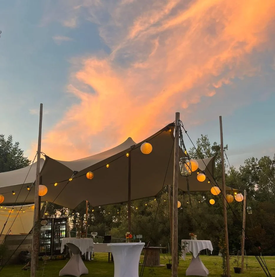 Stretchtent met lampionnen bij zonsondergang