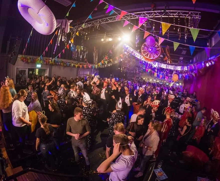 Volle zaal tijdens een feest met vlaggetjes