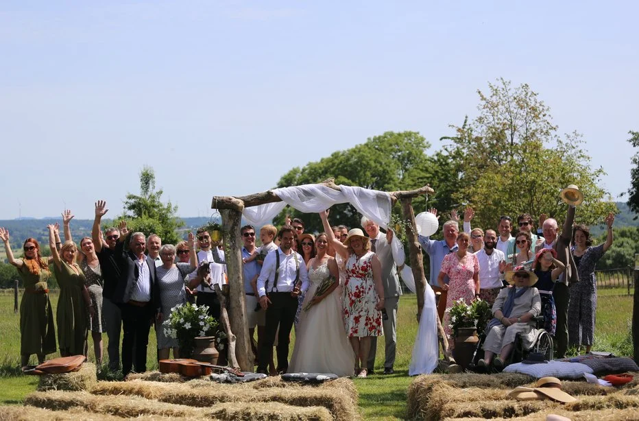 Bruiloftsgasten juichen bij een ceremonieboog